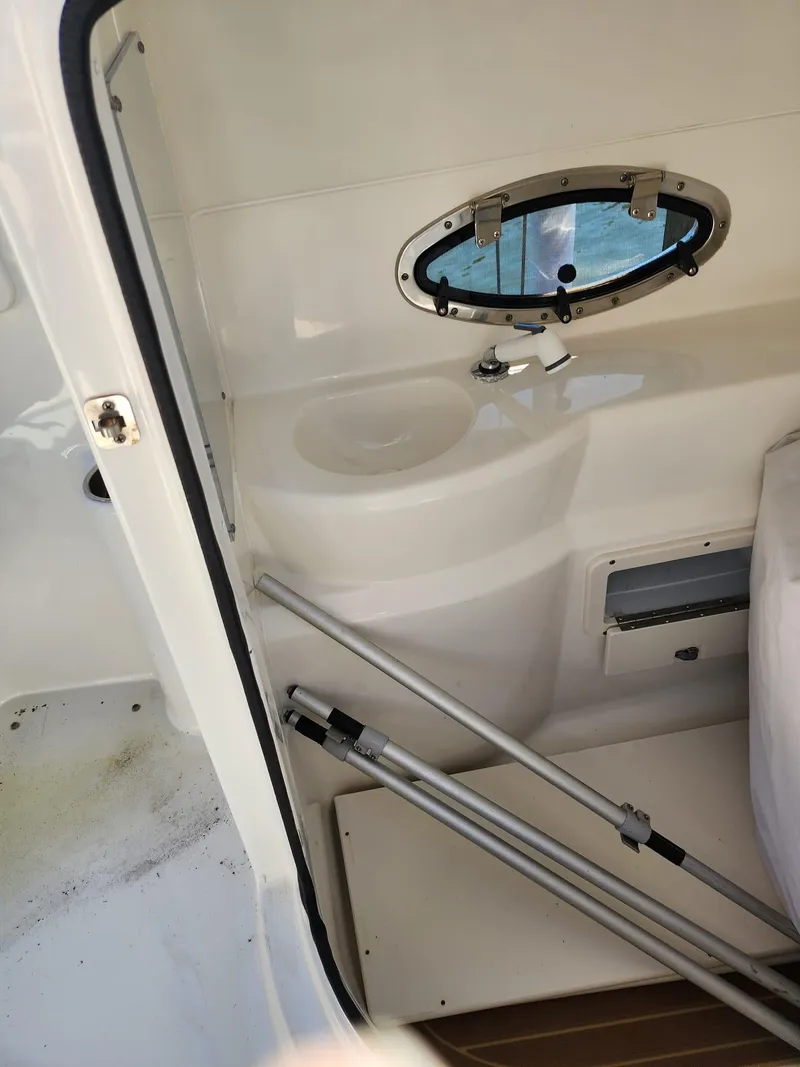Slide: The Image of 2017 NauticStar 243DC Sport Deck interior with porthole and storage area. - 30