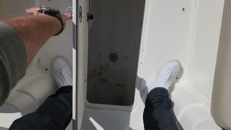 Slide: The Image of 2017 NauticStar 243DC Sport Deck storage compartment being opened. - 32