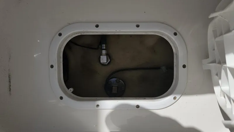 Slide: The Image of 2017 NauticStar 243DC Sport Deck storage compartment with visible wiring. - 38