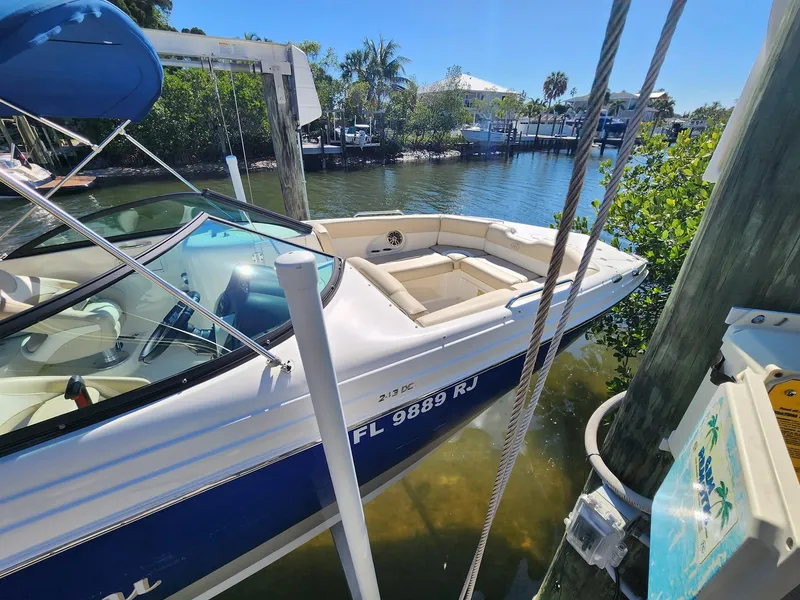 Slide: The Image of 2017 NauticStar 243DC Sport Deck boat docked in a sunny marina. - 5