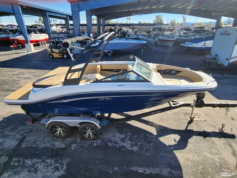 Slide: The Image of 2023 Sea Ray SPX 190 boat on trailer in marina setting. - 1