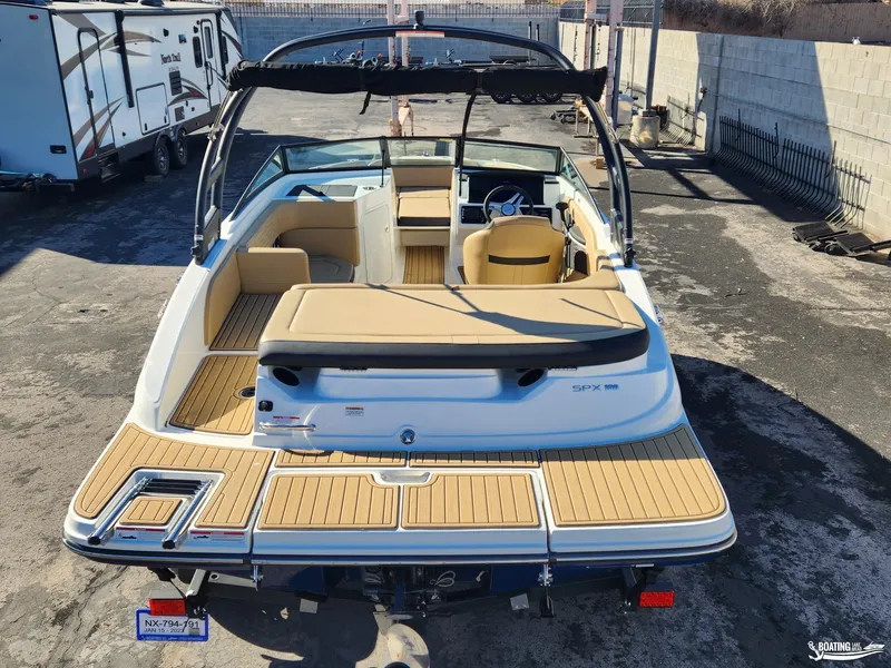 Slide: The Image of 2023 Sea Ray SPX 190 boat with tan seating and swim platform, parked outdoors. - 3