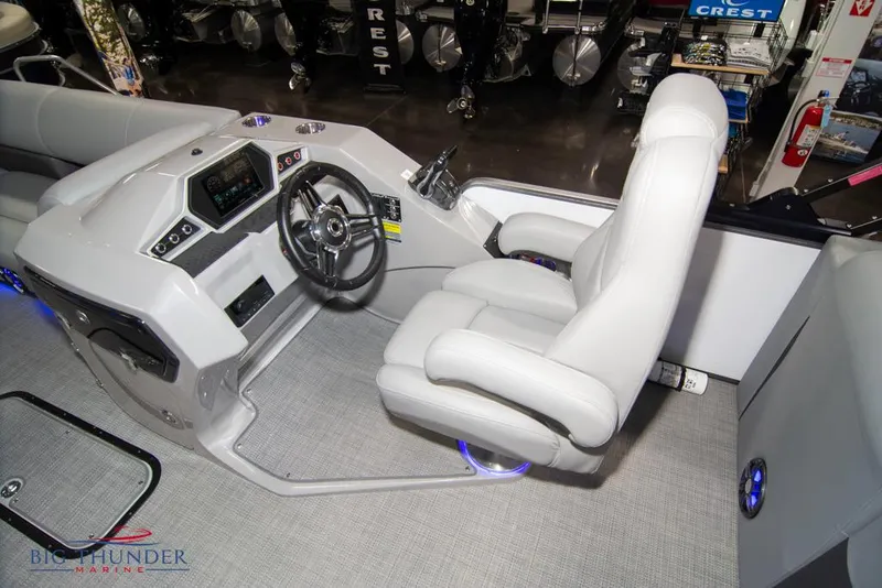 Slide: The Image of 2022 Manitou 25 Oasis SR SHP boat interior with captain's chair and control console. - 28