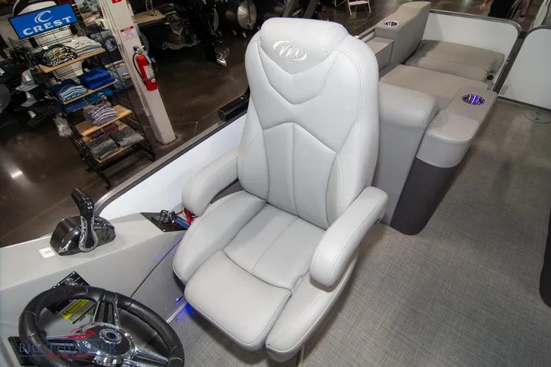 Slide: The Image of 2022 Manitou 25 Oasis SR SHP boat interior with captain's chair and steering wheel. - 29