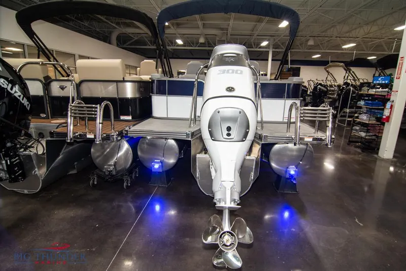 Slide: The Image of 2022 Manitou 25 Oasis SR SHP pontoon boat with powerful outboard motor in showroom. - 3
