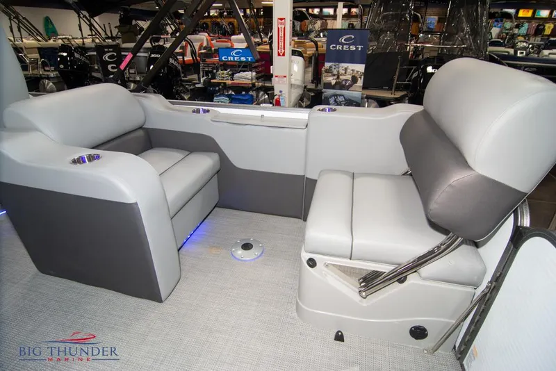 Slide: The Image of 2022 Manitou 25 Oasis SR SHP boat interior with gray seating and blue LED lighting. - 40