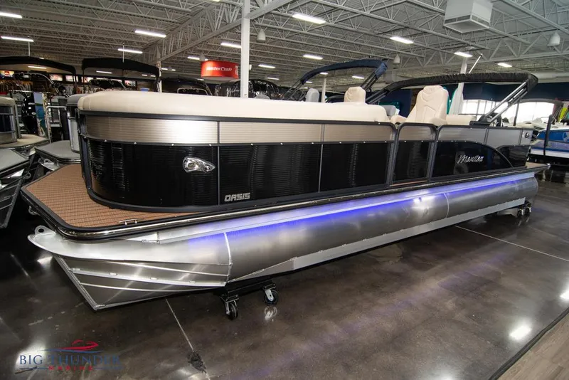 Slide: The Image of 2022 Manitou 25 Oasis SR SHP pontoon boat displayed indoors. - 0
