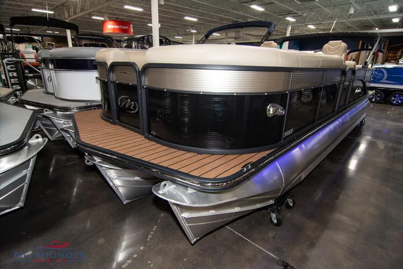 Slide: The Image of 2022 Manitou 25 Oasis SR SHP pontoon boat displayed indoors. - 1