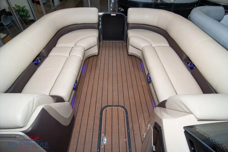 Slide: The Image of 2022 Manitou 25 Oasis SR SHP boat interior with luxurious seating and wood flooring. - 13