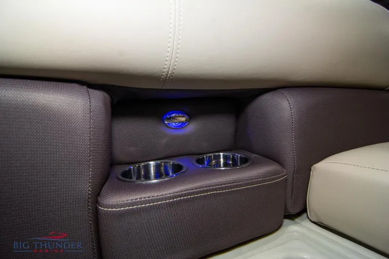 Slide: The Image of 2022 Manitou 25 Oasis SR SHP boat interior with cup holders and ambient lighting. - 15