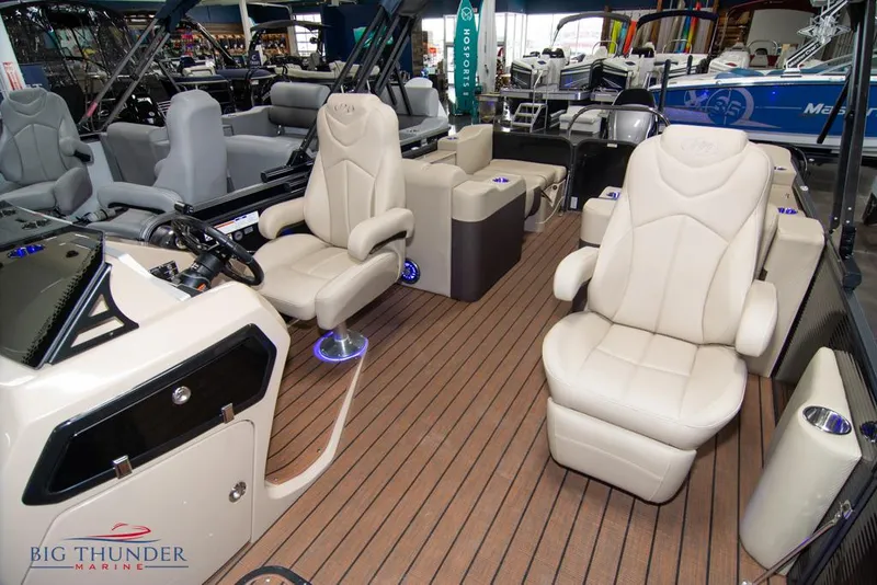 Slide: The Image of 2022 Manitou 25 Oasis SR SHP boat interior with beige seating and wood flooring. - 16