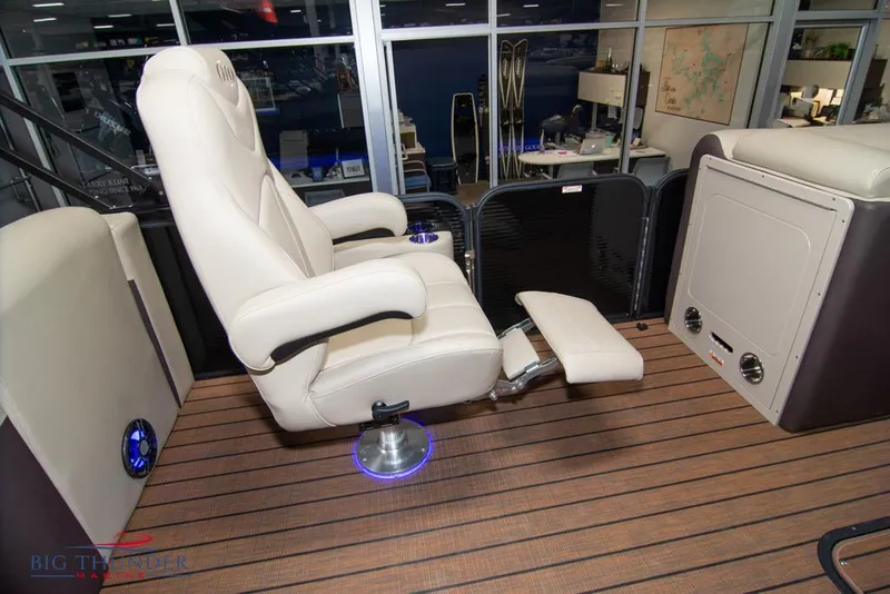Slide: The Image of 2022 Manitou 25 Oasis SR SHP boat interior with luxurious captain's chair and footrest. - 31
