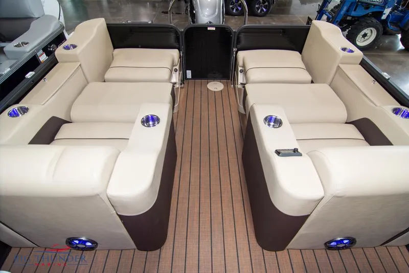 Slide: The Image of 2022 Manitou 25 Oasis SR SHP boat interior with beige seating and cup holders. - 34
