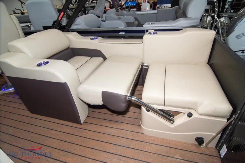 Slide: The Image of 2022 Manitou 25 Oasis SR SHP boat interior with beige seating and wooden flooring. - 38