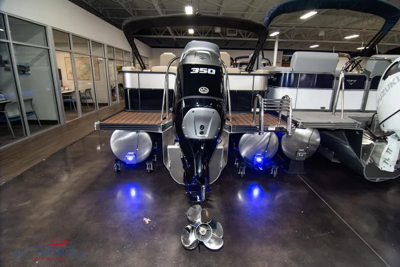 Slide: The Image of 2022 Manitou 25 Oasis SR SHP pontoon boat with 350 HP engine in showroom. - 4