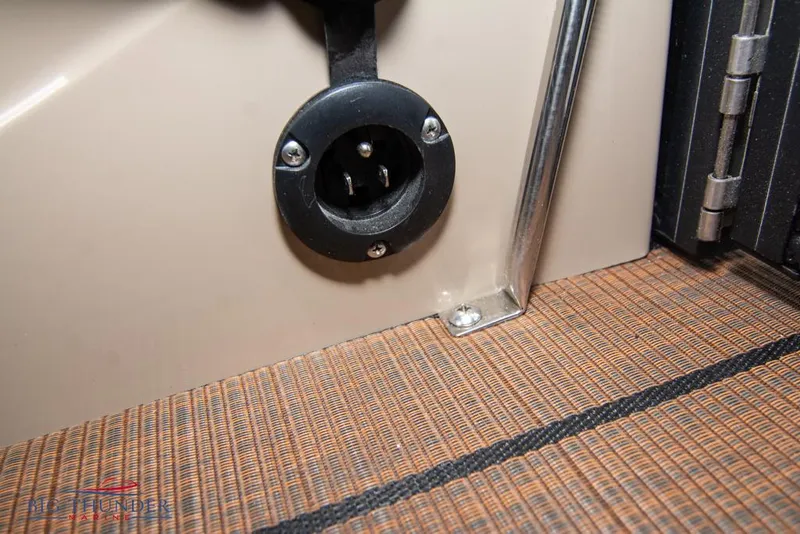 Slide: The Image of 2022 Manitou 25 Oasis SR SHP boat interior detail showing a power outlet. - 40