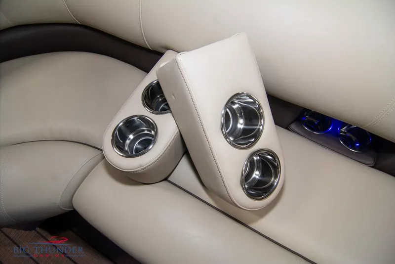 Slide: The Image of 2022 Manitou 25 Oasis SR SHP boat interior with cup holders and beige leather seats. - 49