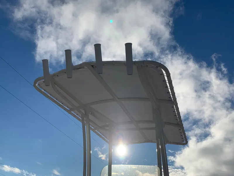 Slide: The Image of 2024 Robalo 206 Cayman T-top against a bright, cloudy sky. - 4