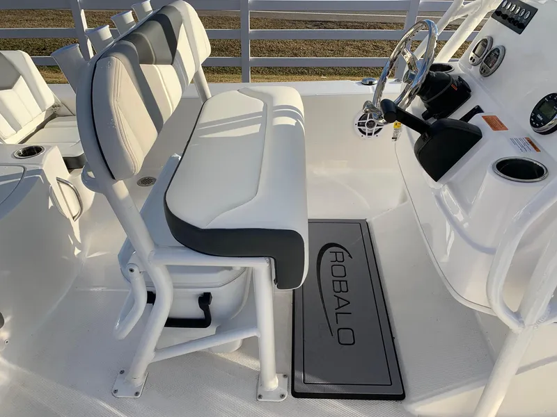 Slide: The Image of 2024 Robalo 206 Cayman boat interior with cushioned seating and steering console. - 8