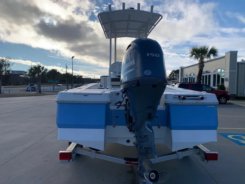 Slide: The Image of 2024 Robalo 206 Cayman boat with Yamaha 150 engine, rear view in a parking lot. - 2