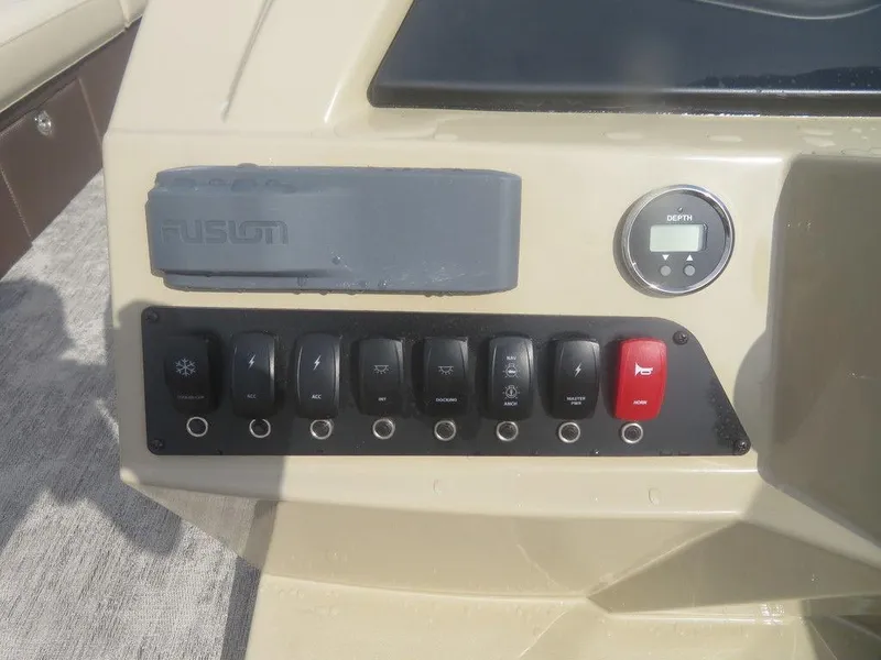 Slide: The Image of Control panel of 2023 Crest Classic LX 240 SLC CPT boat with switches and a digital gauge. - 2