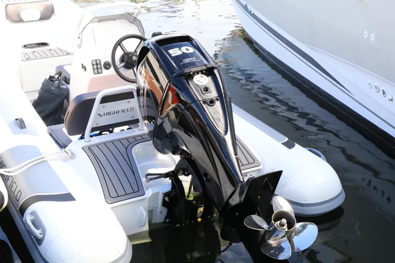 Slide: The Image of 2023 Highfield 390 Sport inflatable boat with 50 HP outboard motor, docked on water. - 1