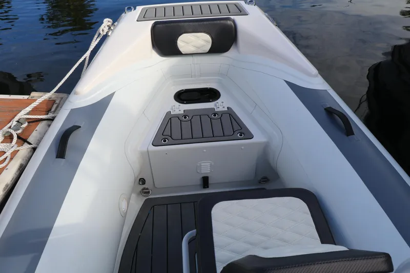 Slide: The Image of 2023 Highfield 390 Sport boat interior with seating and storage, docked by the water. - 13