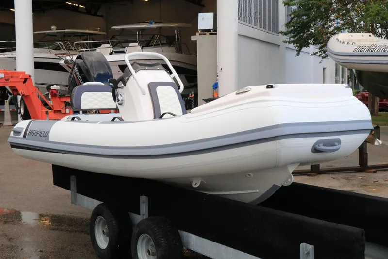 Slide: The Image of 2023 Highfield 390 Sport boat on trailer in marina setting. - 2