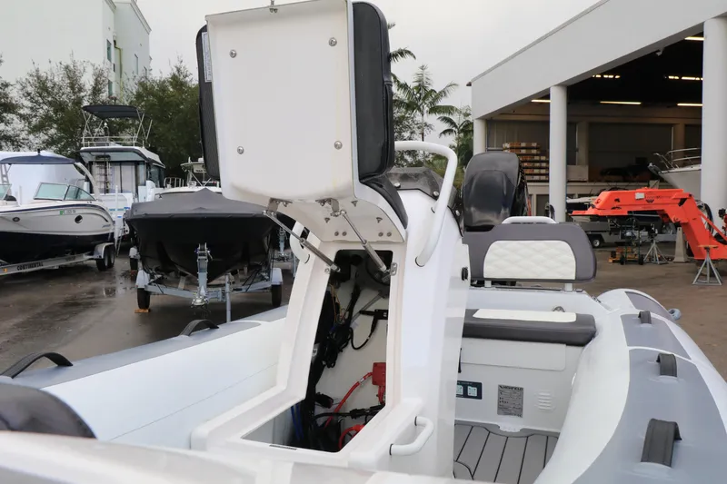 Slide: The Image of 2023 Highfield 390 Sport boat with open storage compartment, displayed at a marina. - 21