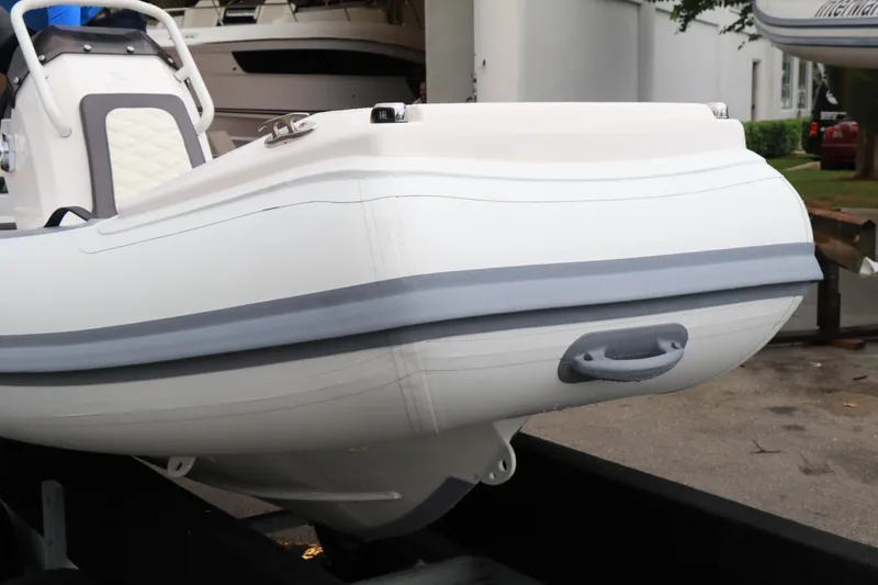 Slide: The Image of 2023 Highfield 390 Sport boat, white hull with gray accents, on a trailer. - 22