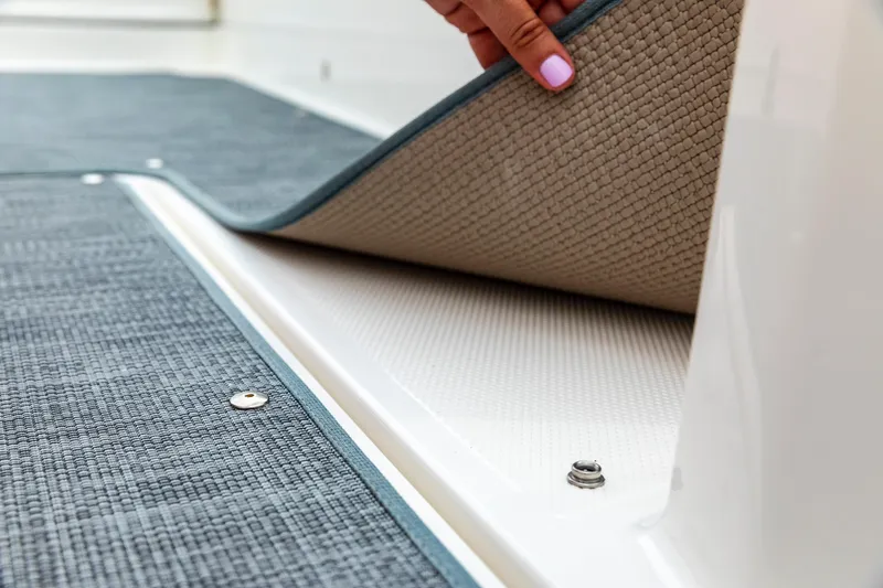 Slide: The Image of 2023 Bayliner VR4 OB boat interior with removable carpet flooring detail. - 11