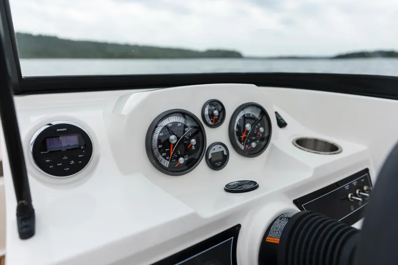 Slide: The Image of 2023 Bayliner VR4 OB dashboard with gauges and controls on a calm lake. - 36