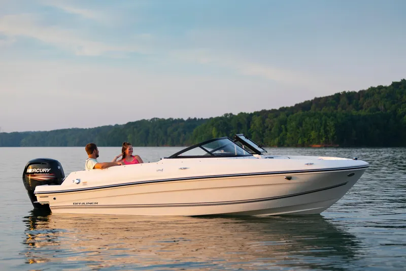 Slide: The Image of 2023 Bayliner VR4 OB boat cruising on a serene lake with two passengers. - 4