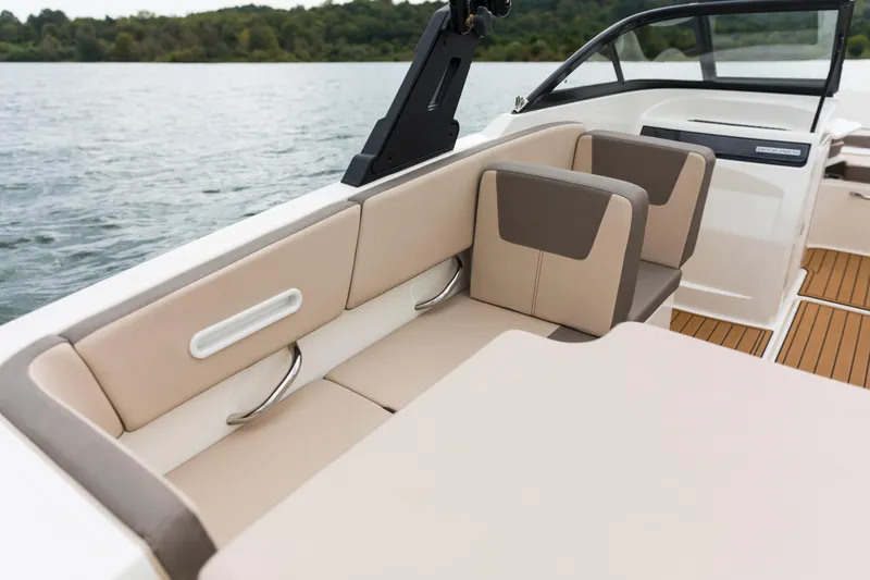 Slide: The Image of 2023 Bayliner VR4 OB boat interior with beige seating and lake view. - 48