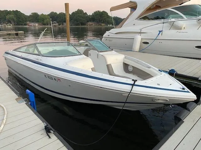 Slide: The Image of 2000 Cobalt 246 boat docked on calm water, surrounded by other boats. - 2