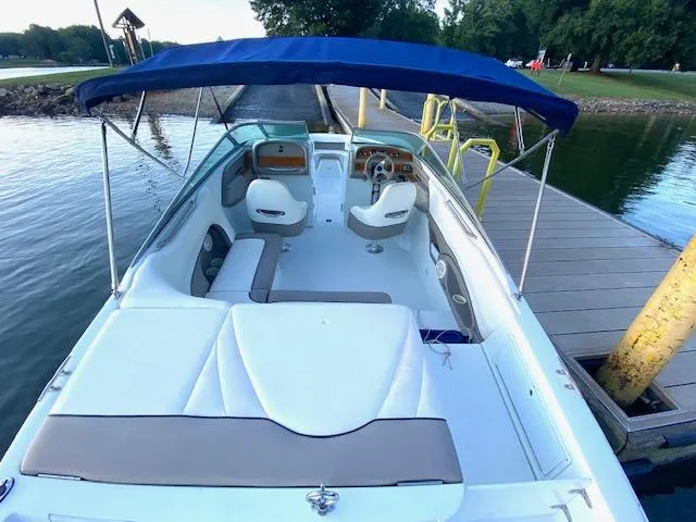 Slide: The Image of 2000 Cobalt 246 boat with blue canopy docked at a lakeside pier. - 4
