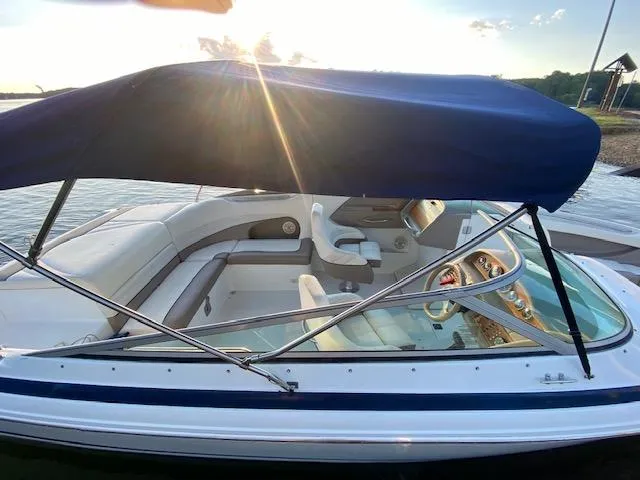 Slide: The Image of 2000 Cobalt 246 boat with blue canopy, docked at sunset. - 5