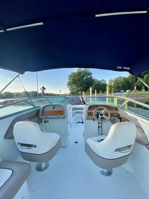 Slide: The Image of 2000 Cobalt 246 boat interior with white seats and blue canopy. - 6