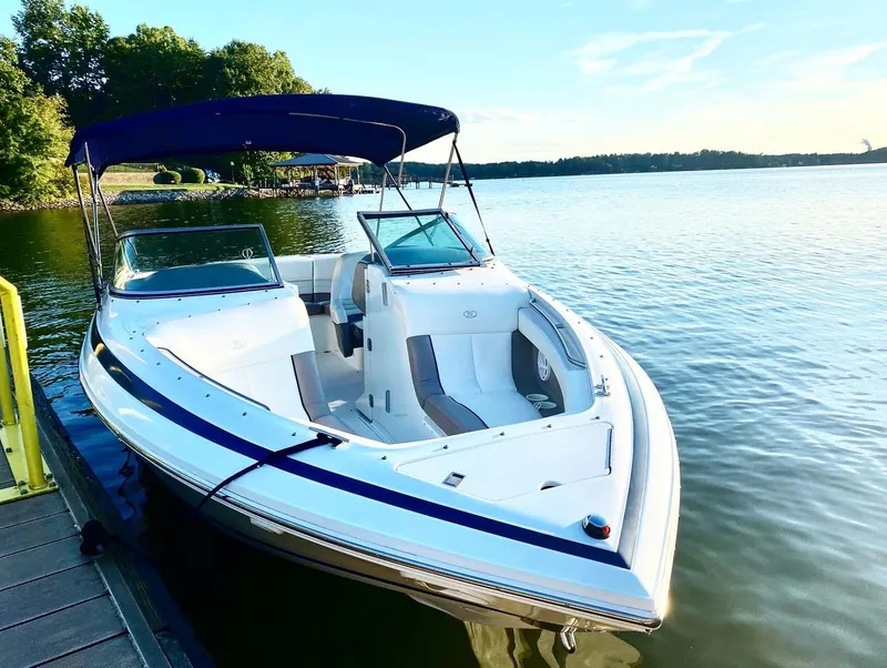 Slide: The Image of Cobalt 246 boat from 2000 docked on a serene lake under a clear sky. - 7