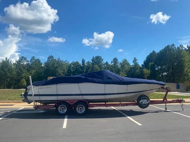 Slide: The Image of Covered 2000 Cobalt 246 boat on trailer in parking lot under blue sky. - 8