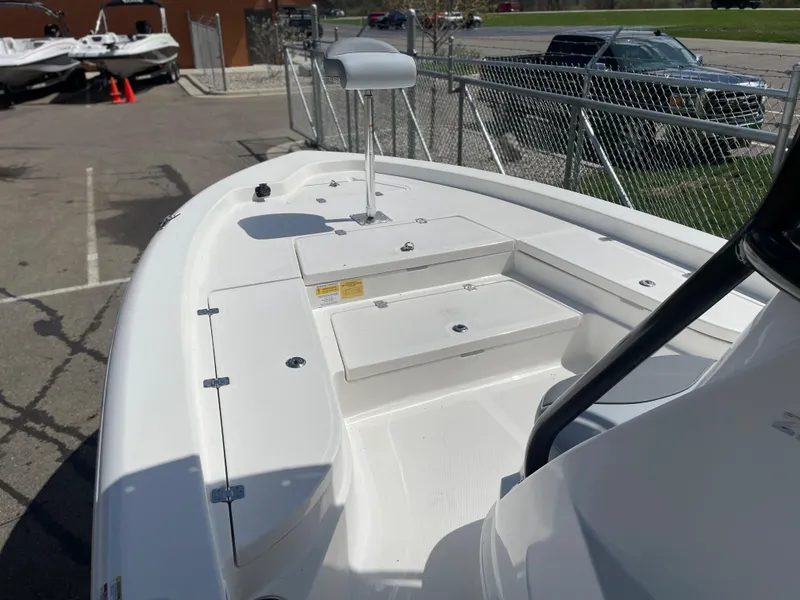 Slide: The Image of 2023 NauticStar 227 Bay boat deck, white, parked outdoors. - 7