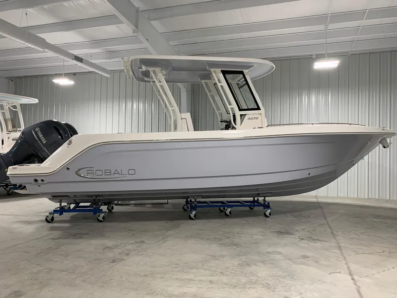 The Image of 2026 Robalo R270 boat in a showroom, side view, on stands. - 1