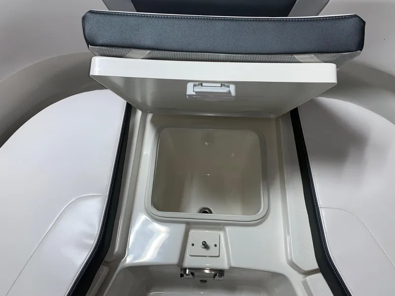 Slide: The Image of 2026 Robalo R270 boat storage compartment with open lid, showcasing interior space. - 10