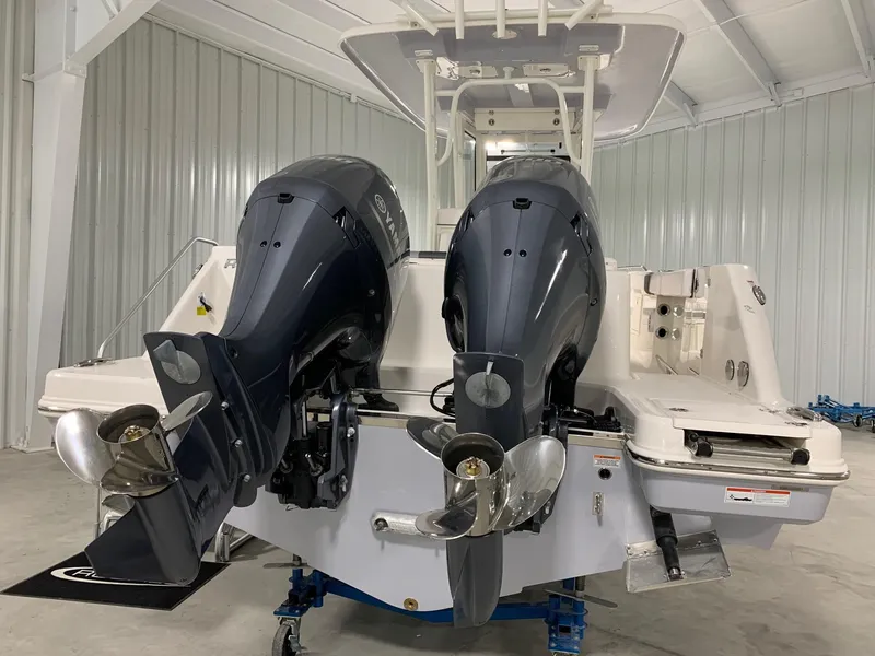 Slide: The Image of 2026 Robalo R270 boat with dual outboard engines in a storage facility. - 3