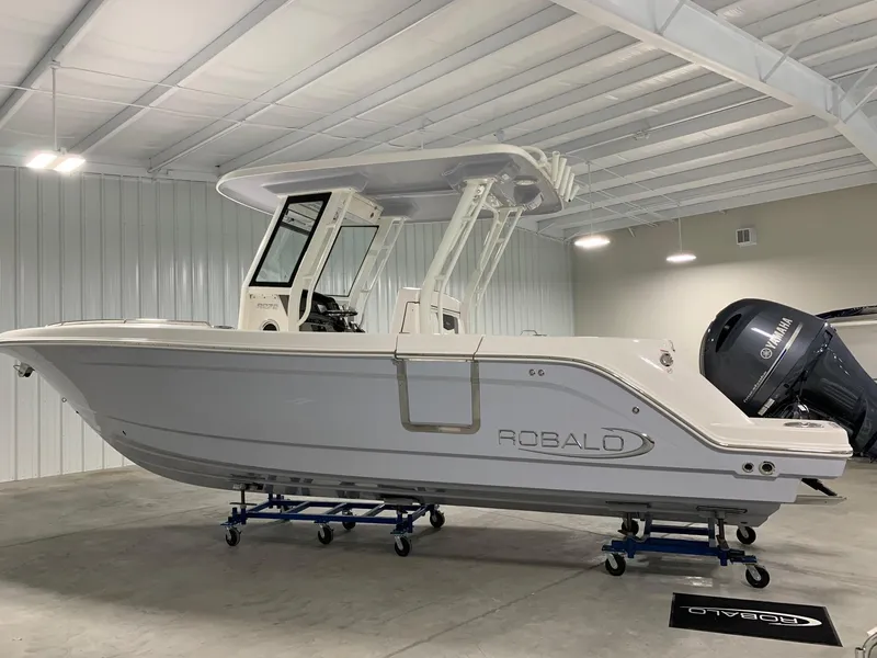 Slide: The Image of 2026 Robalo R270 boat in a showroom, side view, with Yamaha outboard motor. - 6