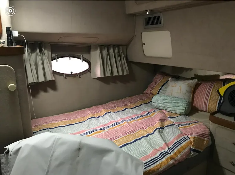 Slide: The Image of 1986 Trojan 14 Meter yacht cabin with cozy bed and striped bedding. - 4
