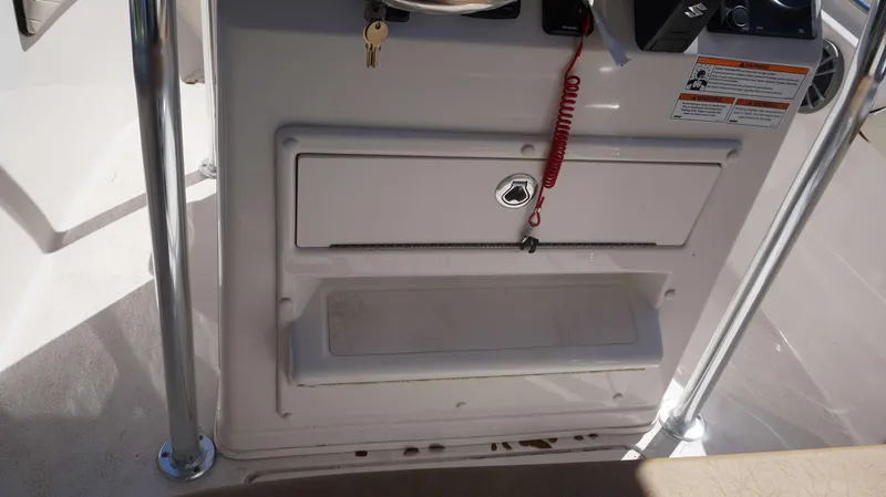 Slide: The Image of Console and storage compartment of 2023 Sea Chaser 20 HFC boat with safety lanyard and keys. - 7