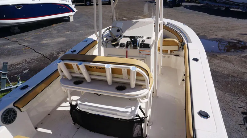 Slide: The Image of 2023 Sea Chaser 22 HFC boat interior with helm and seating, docked outdoors. - 5