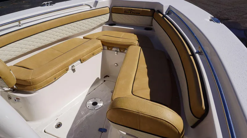 Slide: The Image of 2023 Sea Chaser 22 HFC boat interior with tan cushioned seating and white accents. - 6