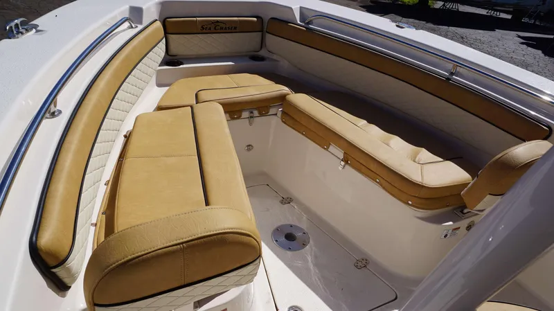 Slide: The Image of 2023 Sea Chaser 22 HFC boat interior with tan cushioned seating and stainless steel railings. - 7